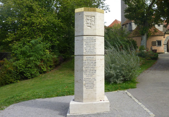 Stauferstele aus hellem Stein mit Inschrift am Stadteingang von Rothenburg ob der Tauber