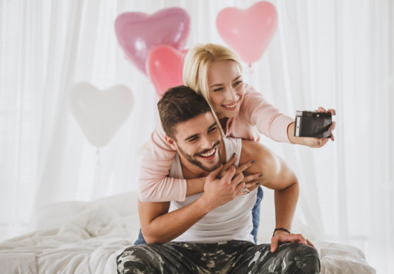 Glückliches Paar macht Selfie vor rosa Herzluftballons – Valentinstag Arrangement im Prinzhotel Rothenburg ob der Tauber