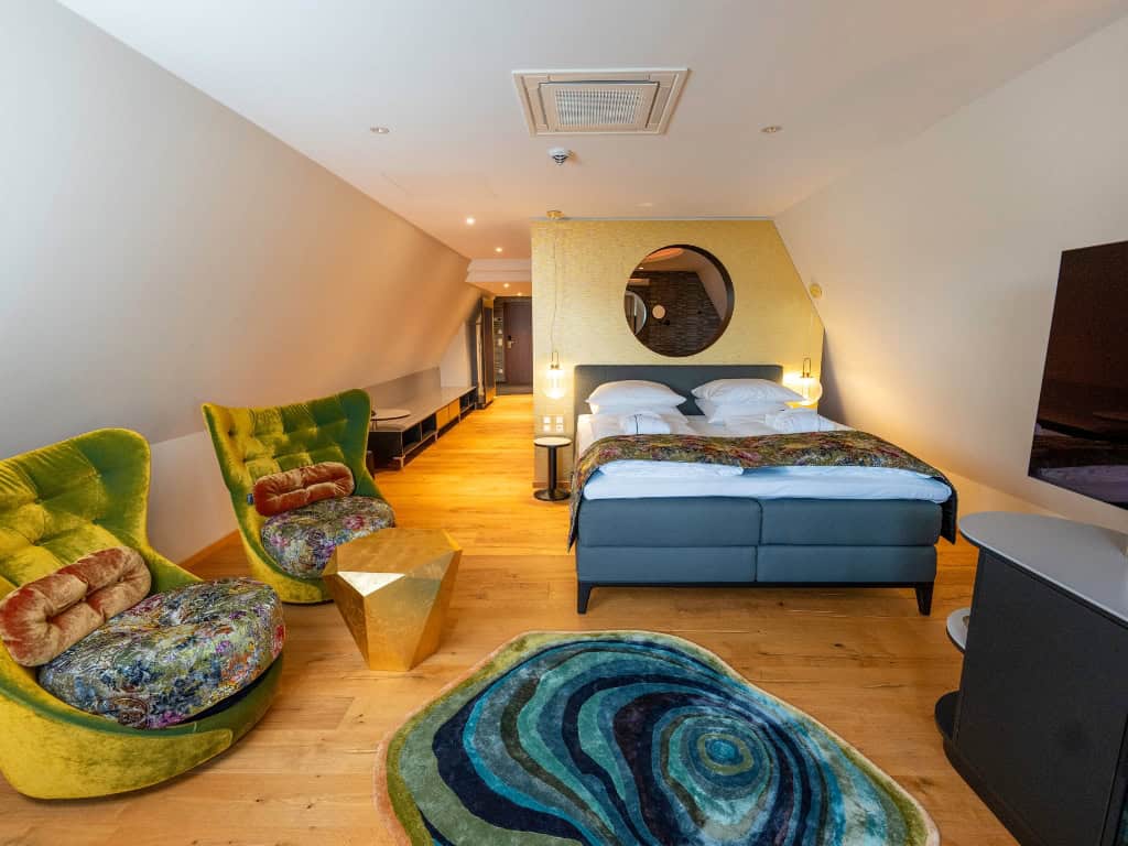 Aqua Spa Suite at the Prinzhotel Rothenburg – elegant living area with designer chairs and double bed