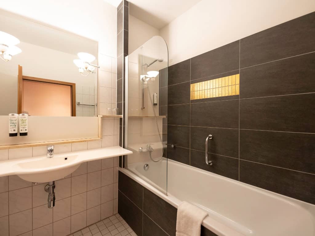 Familienzimmer Prinzhotel Rothenburg – modernes Badezimmer mit Badewanne und Waschbecken