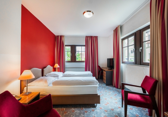 Standardzimmer im Prinzhotel Rothenburg – helles Doppelzimmer mit roter Wand und moderner Einrichtung